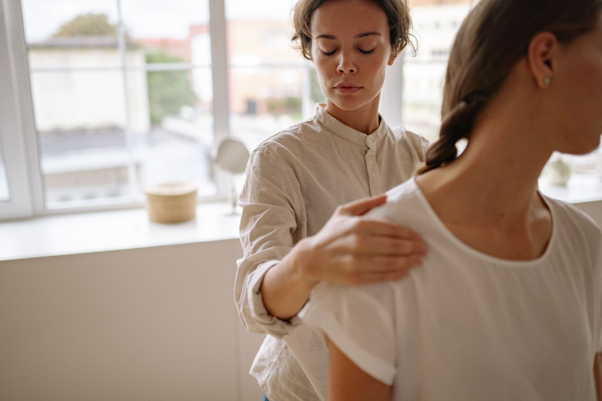 Physiotherapeutin behandelt eine Patientin in hellem Praxisraum
